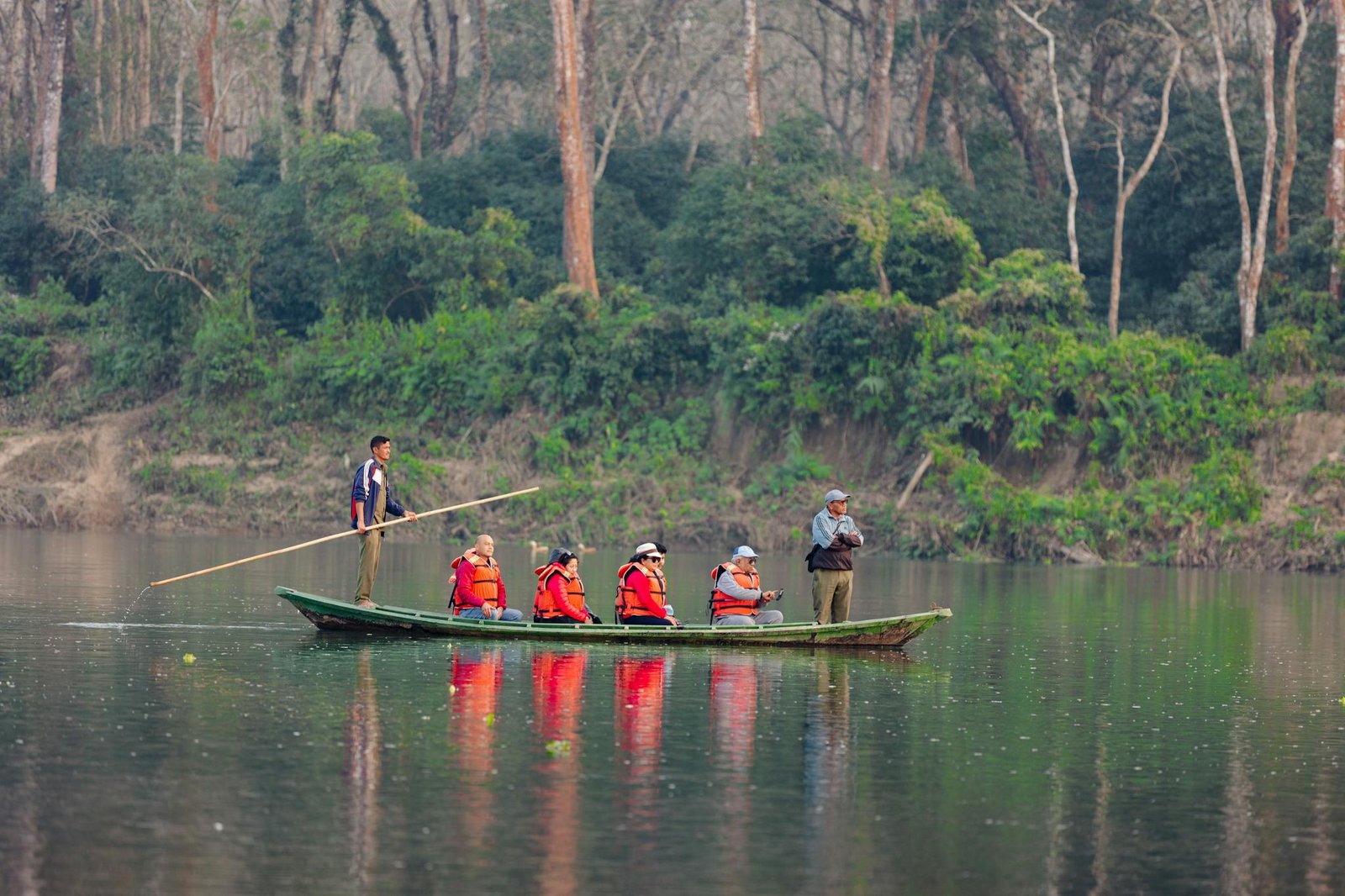 Group enjoying guided canoe ride on a calm forest lake with life jackets