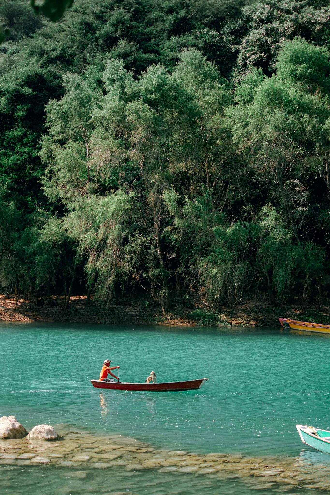 Peaceful scene of a man rowing a canoe on turquoise waters in Ciudad Valles, Mexico.